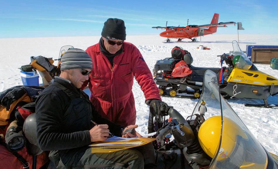 Ein Feldteam von Forschern auf dem Larsen C Eisschelf mit dem Flugzeug im Hintergrund. Durch den drohenden Abbruch konnte kein Camp auf dem Schelf aufgestellt werden. Bild: Peter Bucktrout, BAS